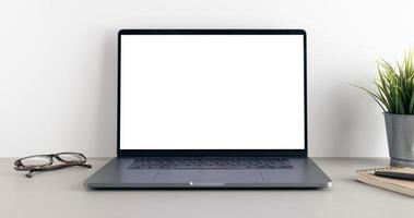 Modern laptop with blank white screen on minimalist desk. Mock up template photo