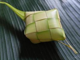 ketupat o bola de masa de arroz es un manjar local durante la temporada festiva. ketupats, una cubierta de arroz natural hecha de hojas de coco jóvenes para cocinar arroz aislado en un fondo blanco foto