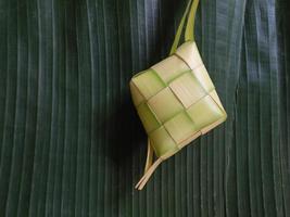 aislado. el ketupat vacío no se ha llenado con arroz. en indonesia, a menudo aparece antes de la celebración de eid al-fitr después del ramadán. concepto de diseño, fondo verde oscuro. foto