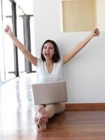 relaxed young woman at home working on laptop computer photo