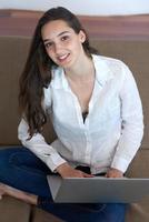 relaxed young woman at home working on laptop computer photo