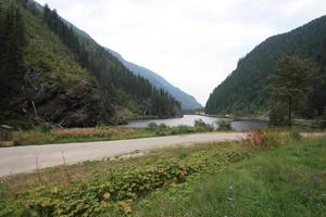 tomado desde el borde de la carretera un lago enclavado entre una cadena montañosa. foto