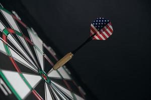 Concept achieving goal.Achieving goals in business, politics and life.Dartboard with darts painted with American flag stuck right into target. photo