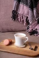 Autumn mood background with cup of cocoa, plaid on sofa. Hot drink in autumn concept