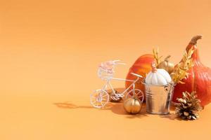 Autumn composition. Dried leaves wreath, pumpkins on orange background. Autumn fall ans thanksgiving day concept. Still life. photo