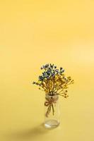 Blue and yellow gypsophila flowers on yellow background. Ukrainian symbolic colors, vertical photo