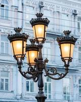 group of bright street lamps on a column illuminating a street photo