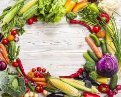 Vegetables spread in a circle on a wooden table photo