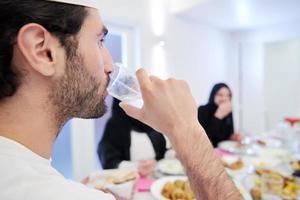 familia musulmana cenando iftar bebiendo agua para romper la fiesta foto