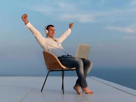 relaxed young man at home on balcony photo