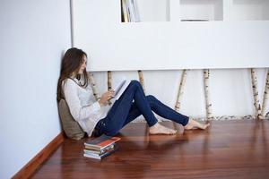 relaxed young woman at home working on laptop computer photo