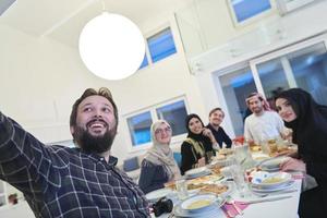 familia musulmana tomando selfie mientras tienen iftar juntos durante el ramadán foto