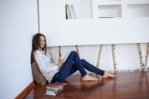 relaxed young woman at home working on laptop computer photo