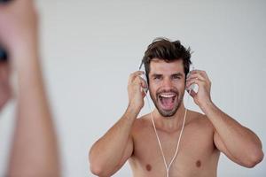 apuesto joven escuchando música en los auriculares foto