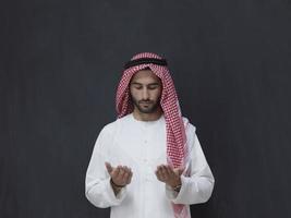 Arab man in traditional clothes praying to God or making dua photo