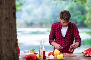 Man cutting meat for barbecue grill photo