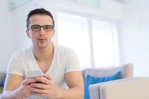 young man using a mobile phone  at home photo