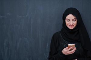 young modern muslim business woman using smartphone photo