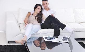 joyful couple relax and work on laptop computer at modern home photo