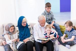 modern muslim grandparents with grandchildren reading Quran photo