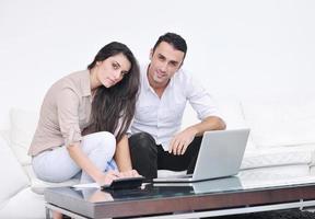 joyful couple relax and work on laptop computer at modern home photo