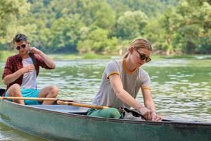 friends are canoeing in a wild river photo