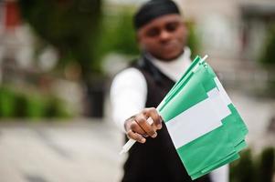 Young african american man hold nigerian flags in hands. photo