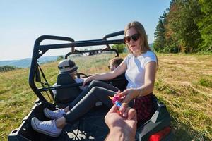 excited people having fun enjoying beautiful sunny day holding colorful torches while driving a off road buggy car photo