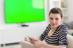 woman on sofa using tablet computer photo