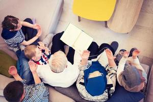 top view of modern muslim grandparents with grandchildren reading Quran photo