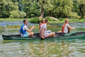 Group adventurous explorer friends are canoeing in a wild river photo