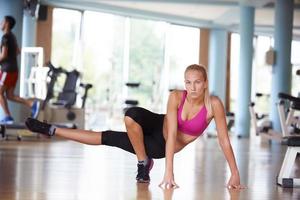 woman stretching and warming up for her training at a gym photo