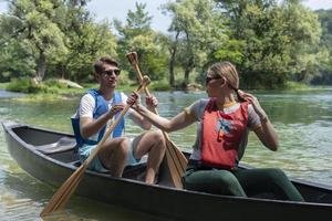 friends are canoeing in a wild river photo