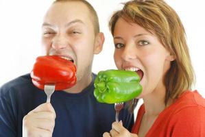 happy couple with eating  peppers photo