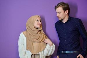 Portrait of happy young muslim couple standing isolated on colorful background photo