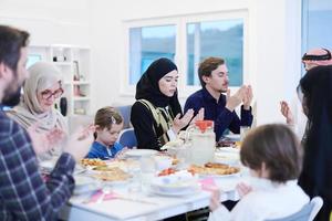 traditional muslim family praying before iftar dinner photo