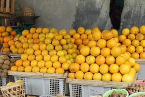 oranges and neat arrangement of fruit in baskets at the traditional market. healthy and fresh orange fruit background photo