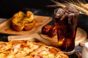 Pizza with cold drink on the black table photo