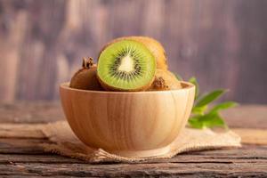 A half of fresh green kiwi in a wood bowl photo