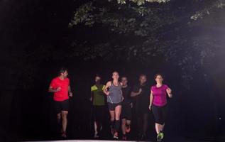 equipo de corredores en el entrenamiento nocturno foto