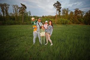 padres con tres hijos divirtiéndose juntos en el prado. foto