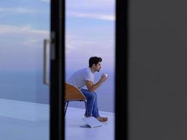 relaxed young man at home on balcony photo