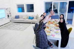 familia musulmana cenando iftar tomando fotos con teléfono móvil