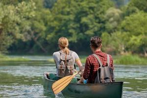 friends are canoeing in a wild river photo