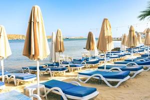 Empty summer beach loungers without people on seaside photo