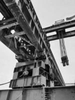 Black and white photo of the steel structure of a launcher gantry that will be used for erection precast concrete I Girde across the river .  This yellow gantry comes from Indonesia.