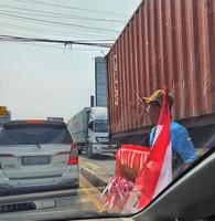 A hawker is selling red and white flags in August. photo