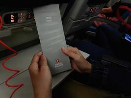 Turkey in July 2022. Two hands are holding a flight meal menu from Turkish Airline. photo