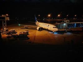A Garuda Indonesia plane is preparing to load passengers for the flight photo