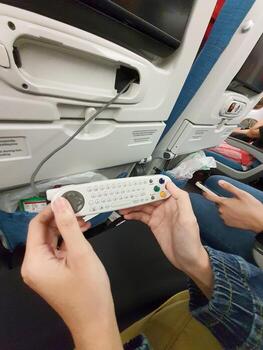 The interior of the passenger seat of a Turkish Airlines plane that has a touch screen for in-flight entertainment. Which is also equipped with a remote controller that also functions as a game stick photo